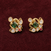 Compact gold-finished floral stud earrings with green, ruby-pink and clear Polki-style stones—ideal for festive and wedding wear.